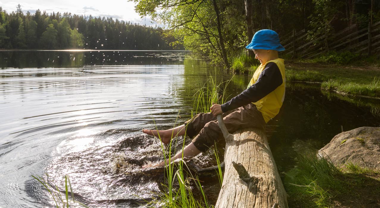 Spielendes Kind am See in Finnland